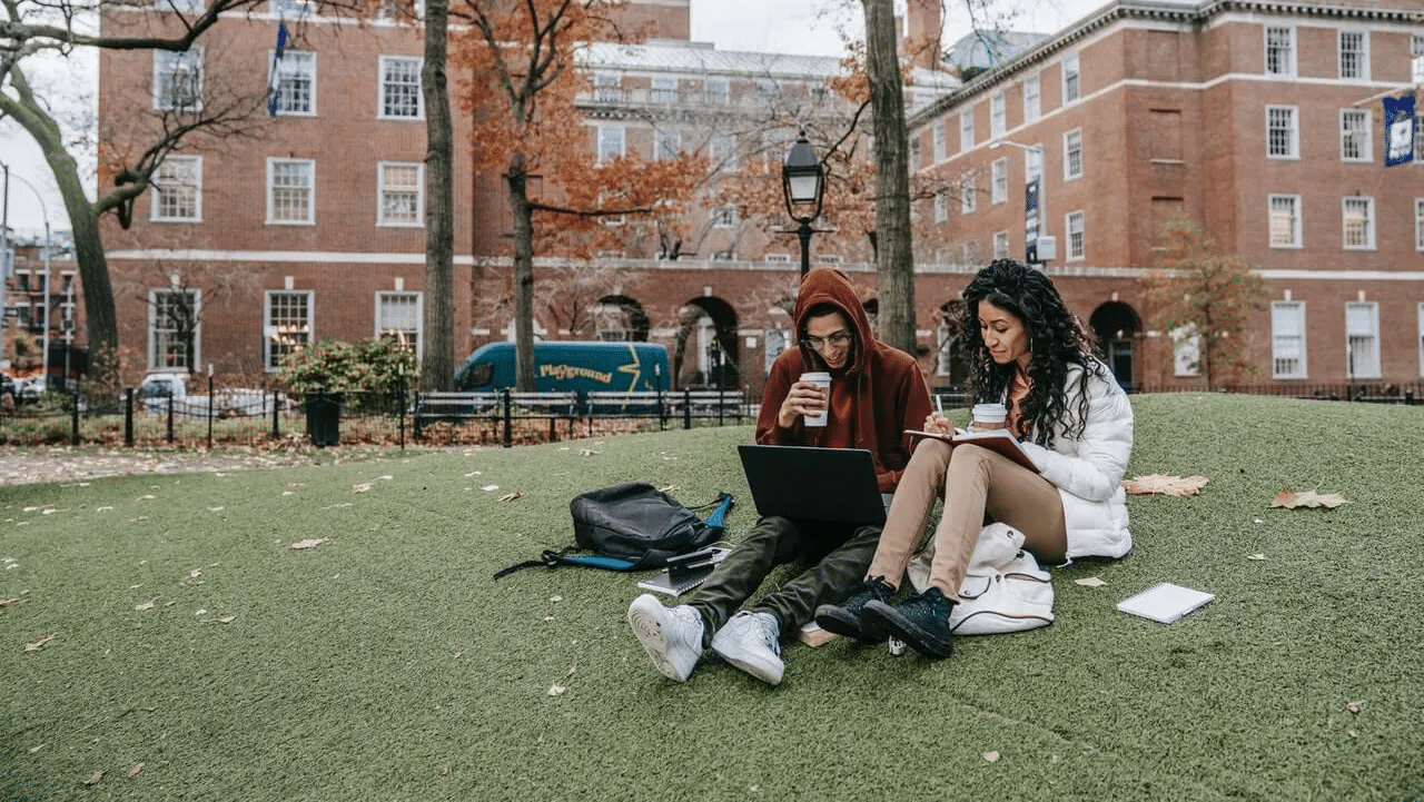 university students studying on lawn, back to school supplies