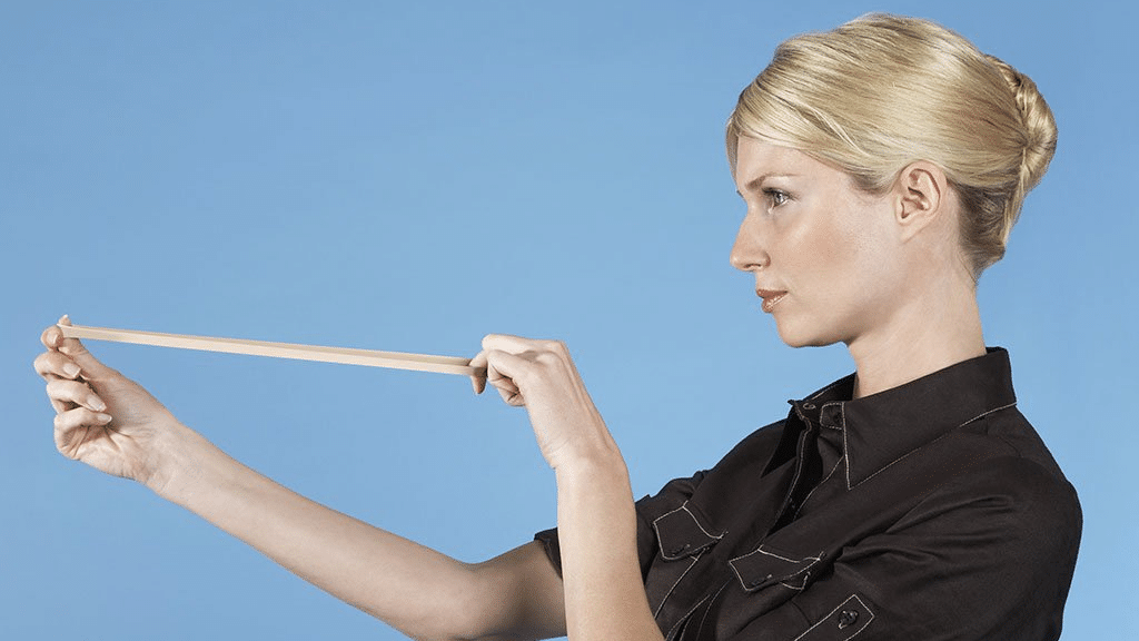 woman holding back a rubber band, school supplies list