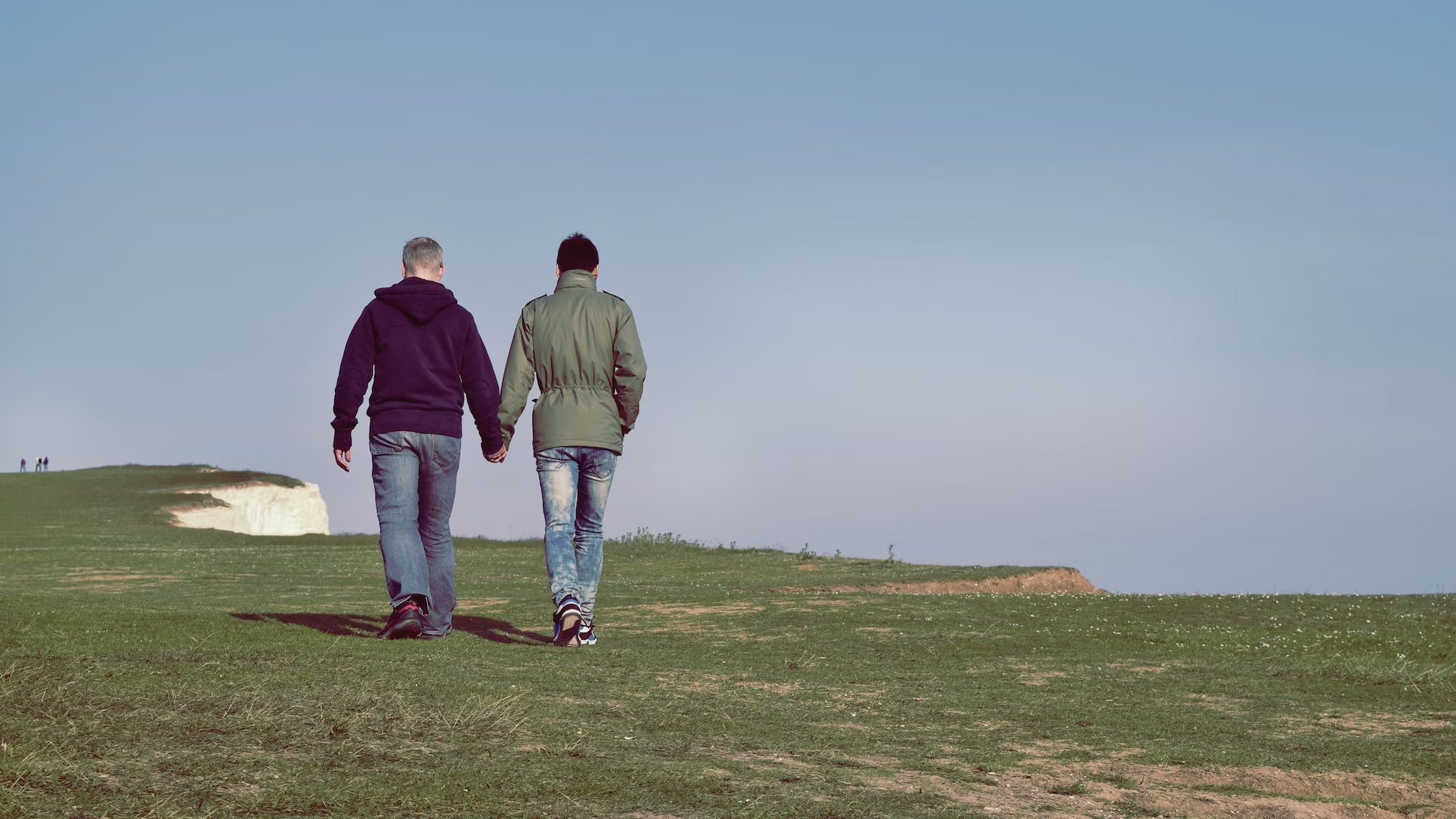 two men holding hands and walking on grass, Testosterone levels