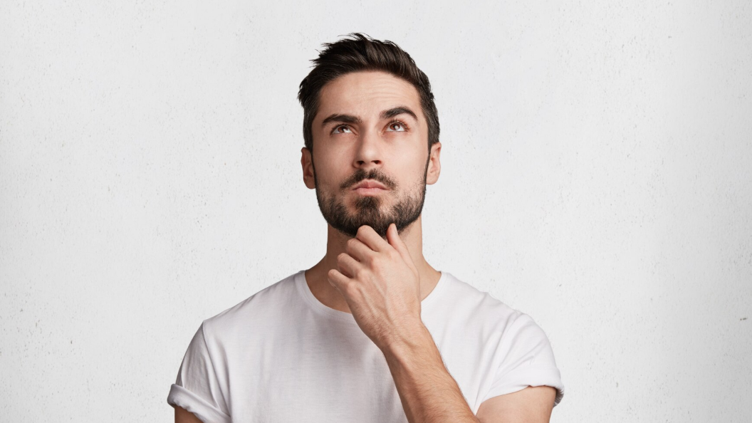 Alt: Man in white shirt pondering