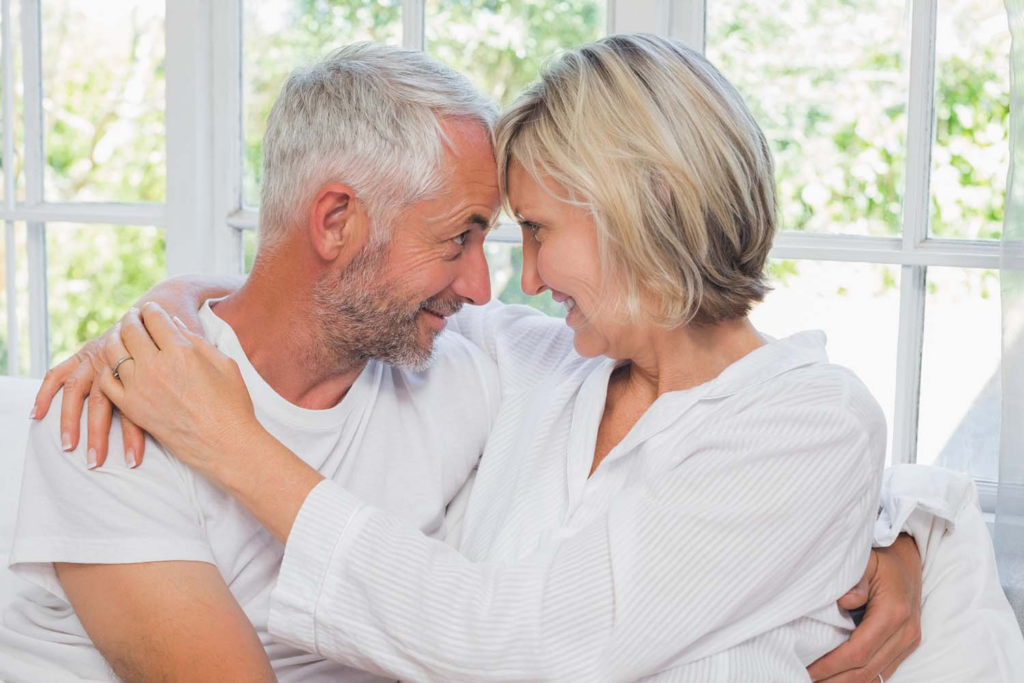 old couple in white hugging
