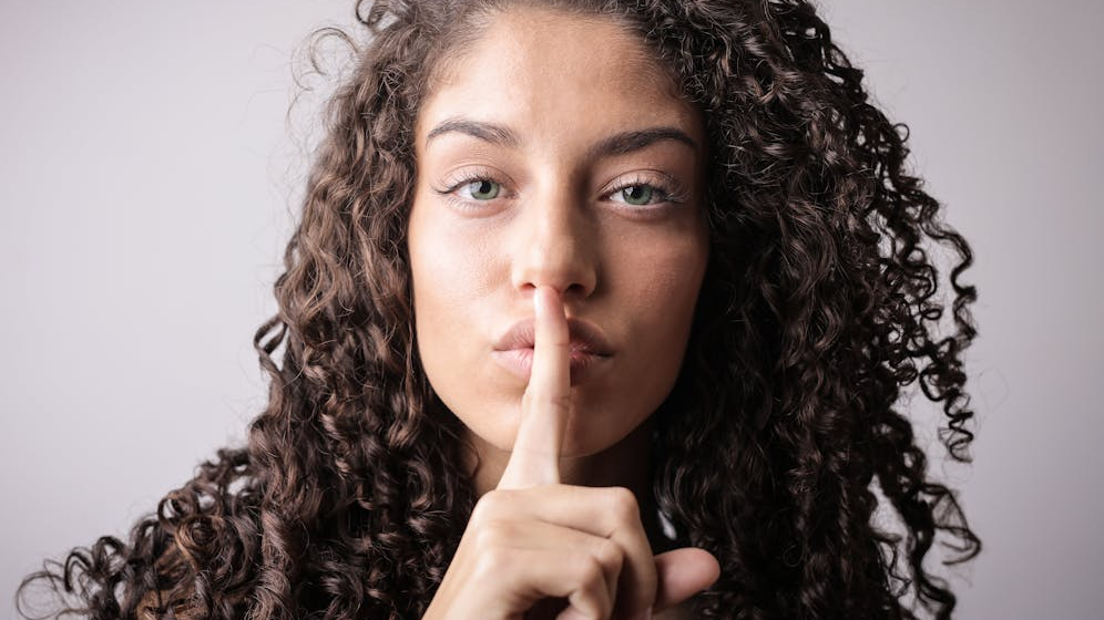 women giving quiet hand gesture