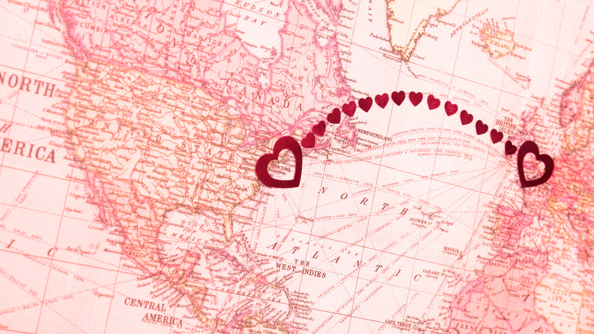 Pink map of the world with two connected hearts