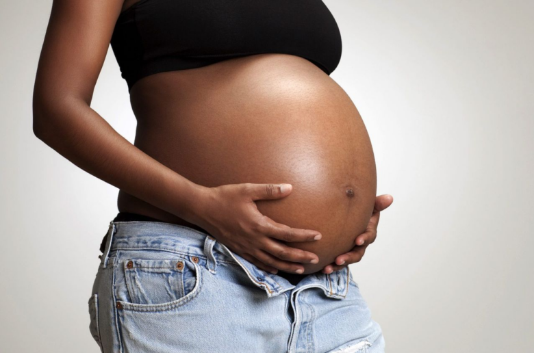 black woman holding her pregnant belly