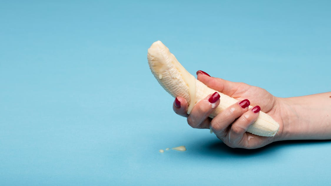 Hand holding banana to insinuate male masturbation