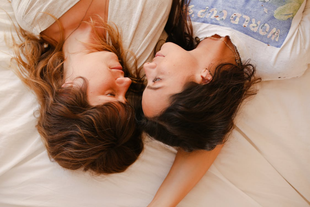 A lesbian couple in bed - image used in reference to relationship myths around women masturbating
