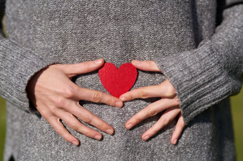 women holding heart over her mid-section in reference to ovulation sex drive