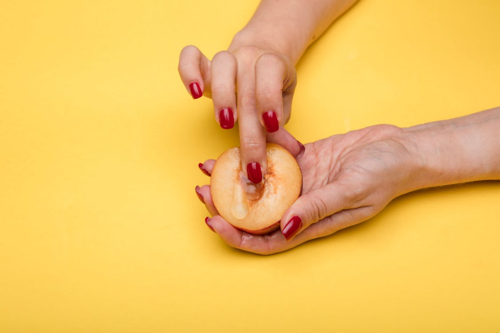 Touch a half peach with sex lube to insinuate women's sexual wellness