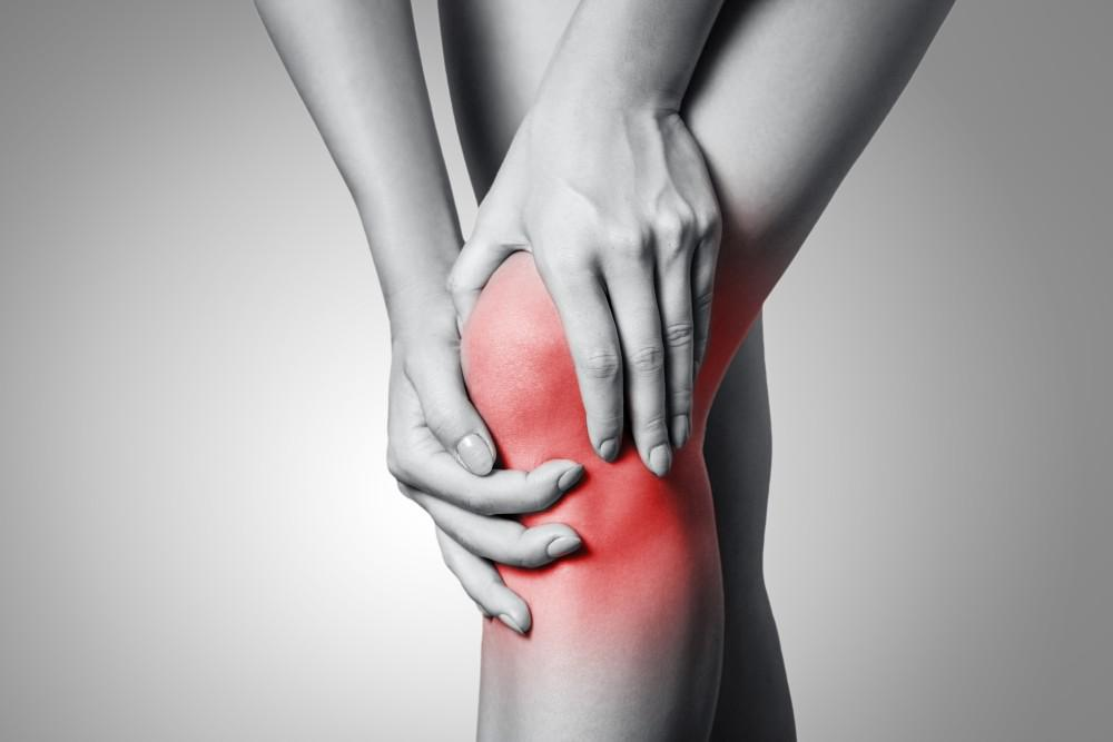 Woman hold knee with join pain in reference to doggy style position