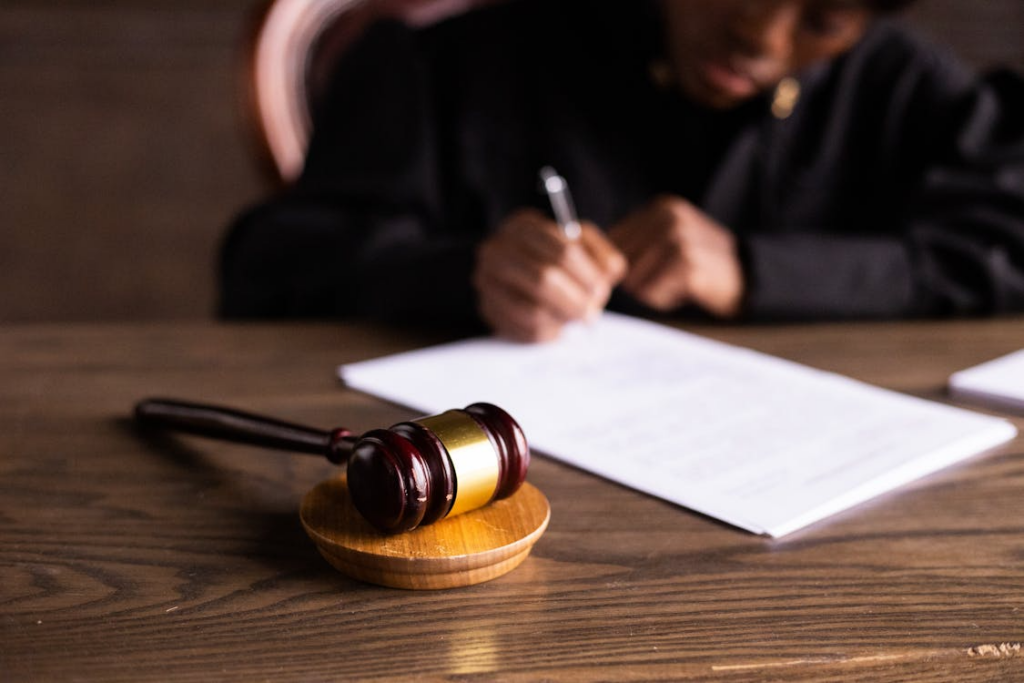 Law gavel in the foreground with a blurred out judge in the back ground 
